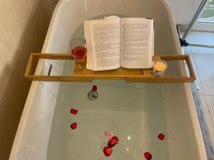 a book and a glass of wine on a shelf in a bath tub at Alojamiento de invitados in Sauzal