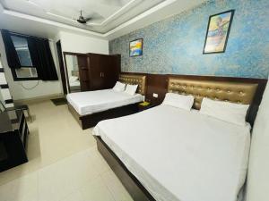 um quarto de hotel com duas camas em Hotel AC family Rooms em Nagla Dhīmar