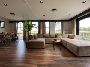 - un salon avec un grand canapé et une table dans l'établissement De Kolibrie, à Garderen