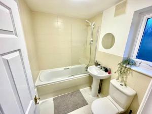 a bathroom with a sink and a toilet and a bath tub at 2 bedrooms haven near NEC, Airport in Curdworth