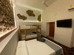Habitación pequeña con cama y TV. en Casa Zaguan, en Cartagena de Indias
