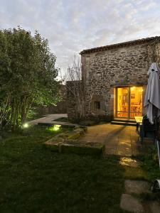 un edificio de piedra con una mesa y una sombrilla en La Casona Medieval, en Malillos