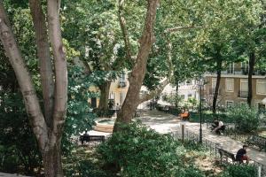 een groep mensen op banken in een park bij Casa C'Alma in Lissabon