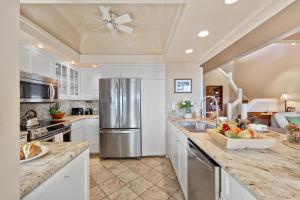 a kitchen with white cabinets and a stainless steel refrigerator at Kapalua Ridge Villas 1423 in Kahana