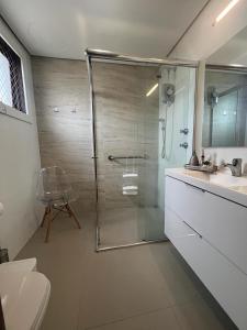 a bathroom with a shower and a toilet and a sink at Flat espaçoso e confortável no Piazza Navona in Porto Alegre