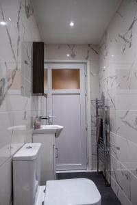 a white bathroom with a toilet and a sink at Lovely family home in Rainham, Kent in Rainham