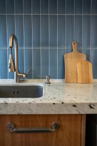 um balcão de cozinha com um lavatório e uma tábua de cortar em Studio Cosmopolita - Novo - possui automação em Nova Santa Medianeira