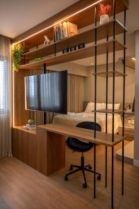 1 dormitorio con escritorio y 1 cama con ordenador en Studio Cosmopolita - Novo - possui automação, en Nova Santa Medianeira