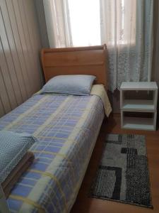 - une chambre avec un lit, une fenêtre et un tapis dans l'établissement Casa Mimosa, à Gramado