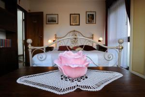 una camera da letto con un letto con un fiore rosa su un tavolo di Villa La Certosa a Pisa