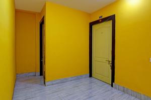 an empty hallway with yellow walls and a door at OYO Shibani & Suhani in Bārang