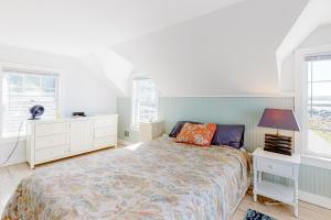 a white bedroom with a bed and two windows at Ipswich Sanctuary in Ipswich