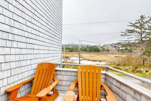 two orange chairs sitting on a balcony with a view at Oceanside Cabin in Neskowin