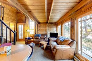 a living room with leather couches and a table at Oceanside Cabin in Neskowin