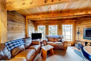 a living room with leather couches and a tv at Oceanside Cabin in Neskowin