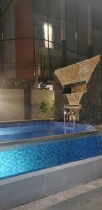 a swimming pool with a fountain in a building at V Canggu Dormitory in Canggu