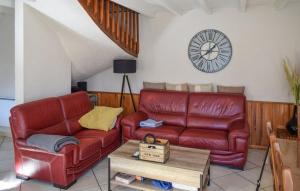 阿戈斯維達洛斯的住宿－Villa avec piscine et vue imprenable，客厅配有红色皮革沙发和时钟