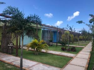 un bâtiment avec des palmiers en face de celui-ci dans l'établissement Vila do Coco - Milagres AL, à São Miguel dos Milagres