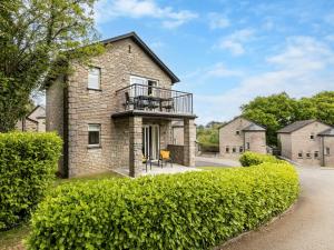 a brick house with a balcony and bushes at 2 Bed in St. Mellion 87712 in St Mellion