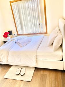 a bedroom with a bed with a window and two slippers at Townhouse in Mill Park