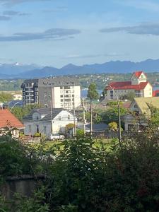 a city with buildings and mountains in the background at The Roses in Puerto Varas