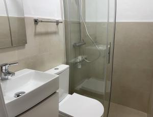 a bathroom with a shower and a toilet and a sink at Chalet en Playa Bahía Algeciras in Palmones