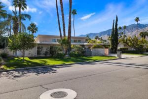 a house on a street with palm trees at The Palms- Pool Jacuzzi and Pet Friendly in Palm Springs