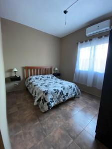 een slaapkamer met een bed en een raam bij kairos in La Falda