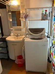 a small bathroom with a sink and a washing machine at 古民家HAKKOU kibi 