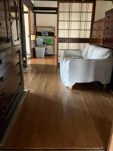 1 dormitorio con 1 cama y suelo de madera en 古民家HAKKOU kibi, 