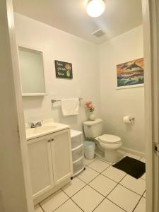 a white bathroom with a toilet and a sink at HUGE 2 bedroom Apt FREE street parking (king bed) in Baltimore