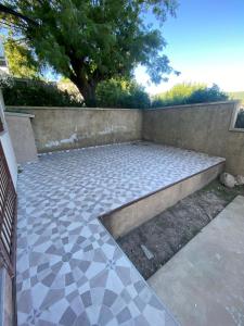 un patio con un banco y una pared en kairos, en La Falda 3 fotos más