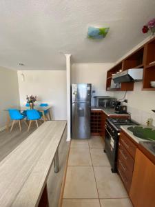 een keuken met een houten aanrecht en een koelkast bij Cómodo y Central Departamento in Talca