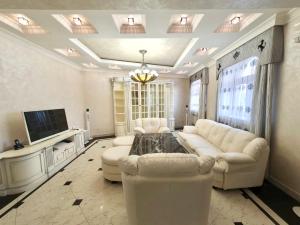 een woonkamer met een witte bank en een tv bij Роскошная двухуровневая квартира Luxurious duplex apartment in Jerevan