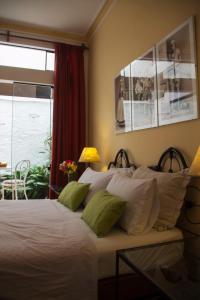 a bedroom with a bed with green and white pillows at El Patio Miraflores in Lima