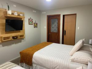 a bedroom with a bed and a flat screen tv at Cabañas Bosque Austral in Punta Arenas