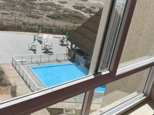 una finestra con vista sulla piscina di Resort Laguna del mar a La Serena