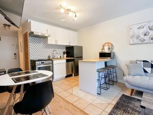 a kitchen and living room with a table and a couch at The Alpine Nest - 3 Beds - 4 Guests - Free Parking - Pool in Mont-Tremblant