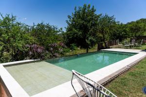 una piscina con un banco en un patio en Cabañas Ascochinga en Ascochinga