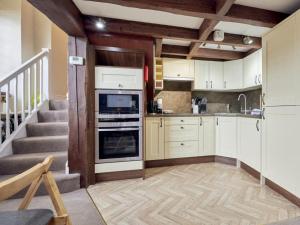 a kitchen with white cabinets and a staircase at 2 Bed in Buttermere SZ588 in Buttermere