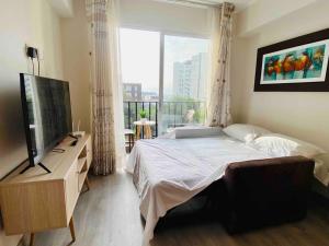 a bedroom with a bed and a television and a balcony at Beautiful floor 9th apartment Pool Gym Barranco in Lima +37 photos