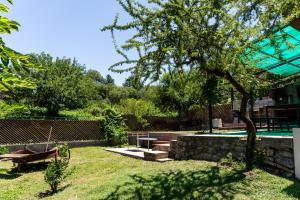 un patio con bancos, un árbol y una piscina en Cabañas Ascochinga en Ascochinga