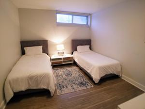 two beds in a small room with a window at Modern and spacious 2 bedroom in Montreal in Montreal