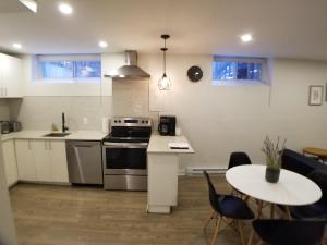 a kitchen with a stove and a table with chairs at Modern and spacious 2 bedroom in Montreal in Montreal