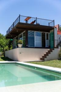 a house with a swimming pool in front of a house at Cabañas Ascochinga in Ascochinga