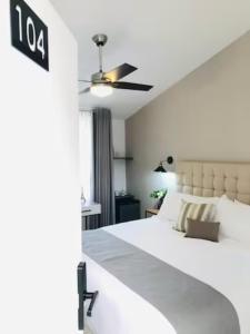 a bedroom with a white bed and a ceiling fan at Urban Chapalita in Guadalajara