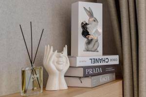 a stack of books with a rabbit statue on a shelf at 영종도 구읍뱃터 오션뷰-Luxe 베드,넷플릭스, 사운드바, 식물테리어, 무료주차 in Incheon