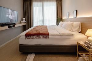 仁川にある영종도 구읍뱃터 오션뷰-Luxe 베드,넷플릭스, 사운드바, 식물테리어, 무료주차のベッドとテレビが備わるホテルルームです。