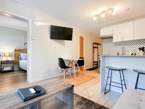 a kitchen and a living room with a table in a room at The Alpine Nest - 3 Beds - 4 Guests - Free Parking - Pool in Mont-Tremblant