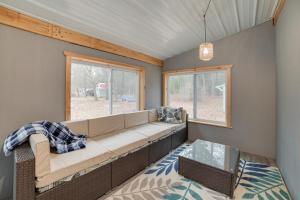 uma sala de estar com um sofá e uma janela em Scenic Evans Hideaway Steps to Lake Huron! em Oscoda